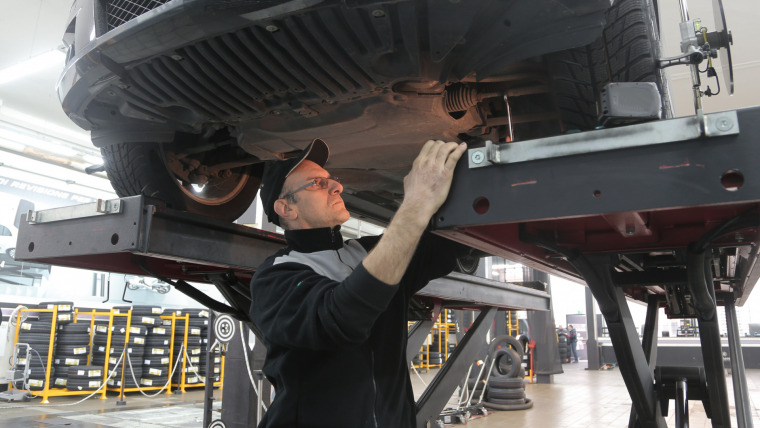 pman in black standing under vehicle