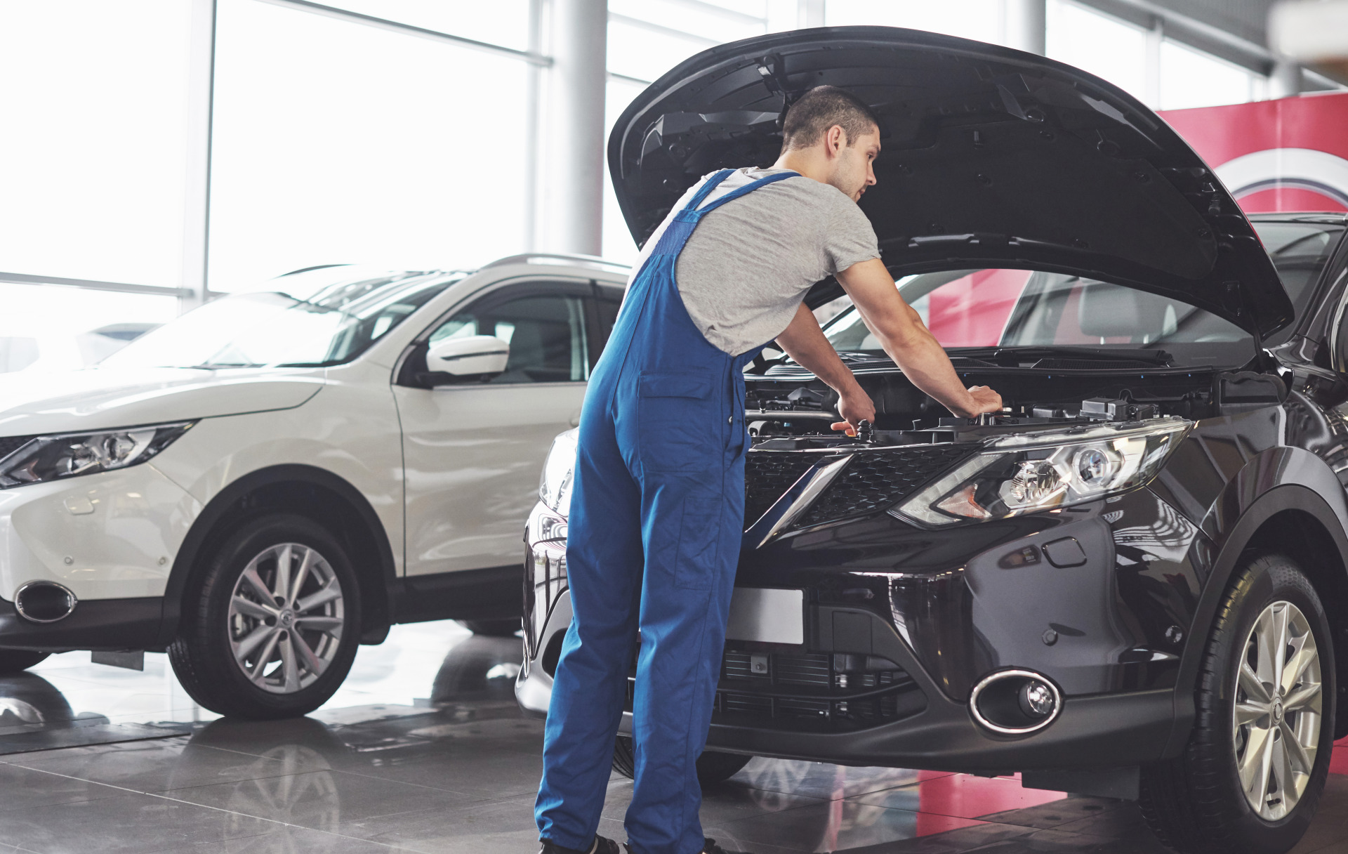 muscular car service worker repairing vehicle